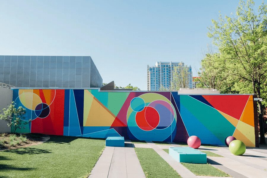 Mural on a brick wall with colorful geometric shapes